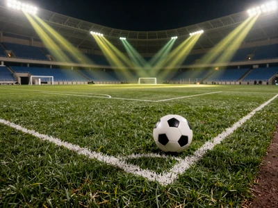 Fu&szlig;ballplatz mit Ball auf dem Elfmeterpunkt unter Flutlichtern